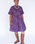 Model wearing purple and black floral print dress.