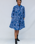 Model wearing blue shaded leaf print dress.