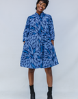 Model wearing blue shaded leaf print dress.