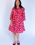 Model wearing red dress with pink flower print.