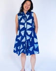 Model wearing blue sleeveless dress with white triangle print.