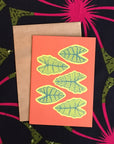 Red greeting card with yellow and green tropical leaves