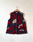 Display of navy sleeveless shirt with red and beige abstract print.