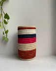 Display of navy, beige, brown and pink striped vase