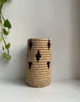 Display of beige vase with black diamonds and triangles