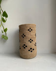 Display of beige and black colored vase with floral design