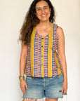 The model is wearing olive-yellow, blue, orange and white geometric printed tank
