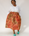 Model wearing multicolored dot print skirt.