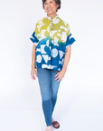Model wearing yellow, green and blue geometric print batik shirt.
