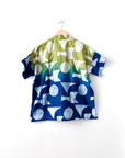 Display of yellow, green and blue geometric print batik shirt.