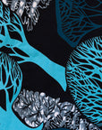 Close up display of sleeveless dress with blue tree print, fabric.