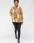 Model wearing yellow, brown and white abstract print shirt.
