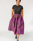 Model wearing fuchsia skirt with small dot design.