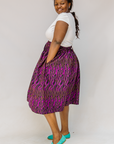 Model wearing fuchsia skirt with small dot design.