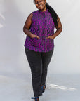Model wearing purple and black abstract print sleeveless shirt.