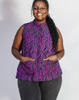 Model wearing purple and black abstract print sleeveless shirt.