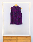Display of purple and black abstract print sleeveless shirt.