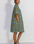 Model wearing blue, yellow, orange and black geometric print dress.