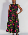 Model wearing navy and green dress with pink floral print.