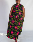 Model wearing navy and green dress with pink floral print.