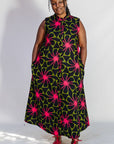 Model wearing navy and green dress with pink floral print.