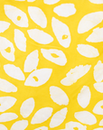 Close up display of yellow long sleeve shirt with white leaf print, fabric.
