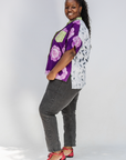 Woman wearing a colorful patterned shirt with a white background
