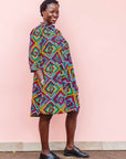 The model is wearing geometric print with rainbow colored dress