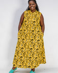 Model wearing yellow dress with black and white paisley print.