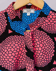 Display of coral, blue and black circular print dress