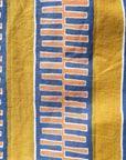 Close up display of yellow pants with blue stripe, fabric.