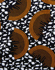 Display of black and white dress with orange half circle print.