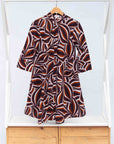 Display of brown, orange, burgundy and white abstract print dress.