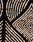 Close up display of black and beige abstract print blouse, fabric.