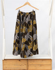 Display of brown leaf print culotte bottoms.
