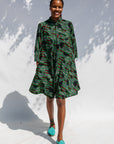 Model wearing green camo print like dress.