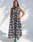 Model wearing black and white floral print, sleeveless dress.