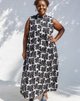 Model wearing black and white floral print, sleeveless dress.