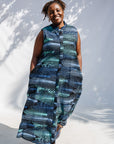Model wearing black dress with aqua and navy abstract print.