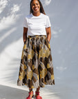 Model wearing brown leaf print culotte bottoms.