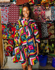 The model is wearing multi colored geometric print dress