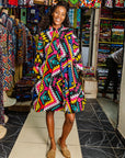 The model is wearing multi colored geometric print dress