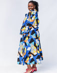 Model wearing blue, black, orange, yellow and white geometric print shirt and pant set.