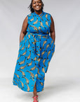 Model wearing blue dress with beige fish print.
