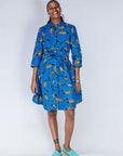 Model wearing blue dress with beige fish print.