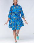 Model wearing blue dress with beige fish print.