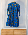 Display of blue dress with beige fish print.