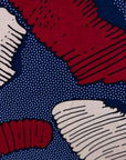 Close up display of navy sleeveless shirt with red and beige abstract print, fabric.