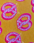 Pattern of pink pretzels on a yellow background