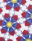 Close up display of white dress with yellow, red and blue bug print.